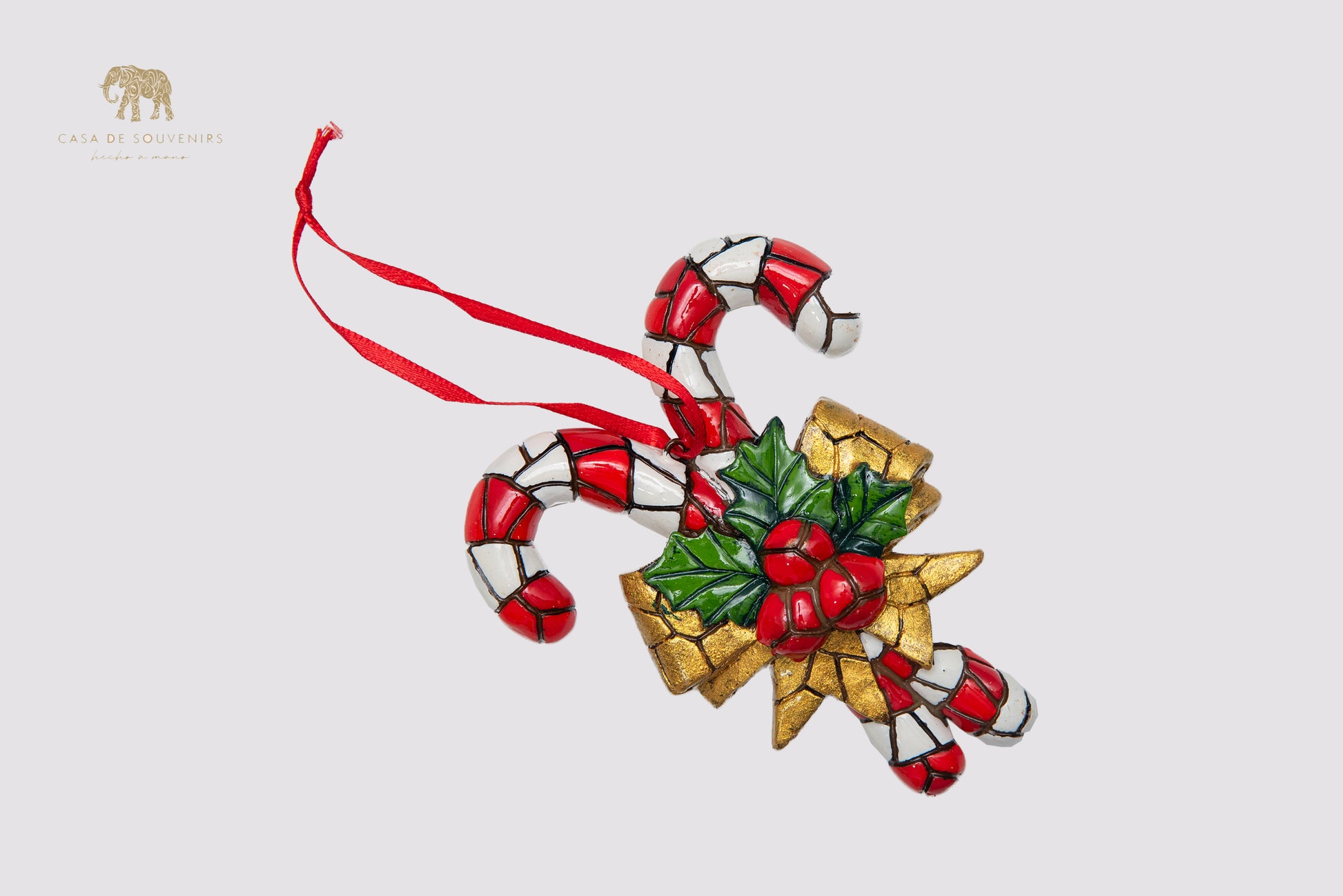 A handmade Christmas ornament featuring a design of candy canes decorated with a colorful mosaic.