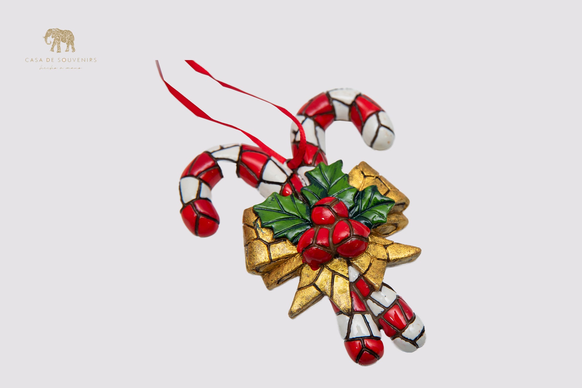 A handmade Christmas ornament featuring a design of candy canes decorated with a colorful mosaic.