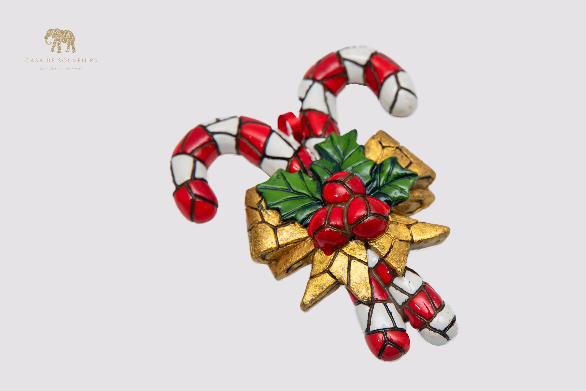 A handmade Christmas ornament featuring a design of candy canes decorated with a colorful mosaic.